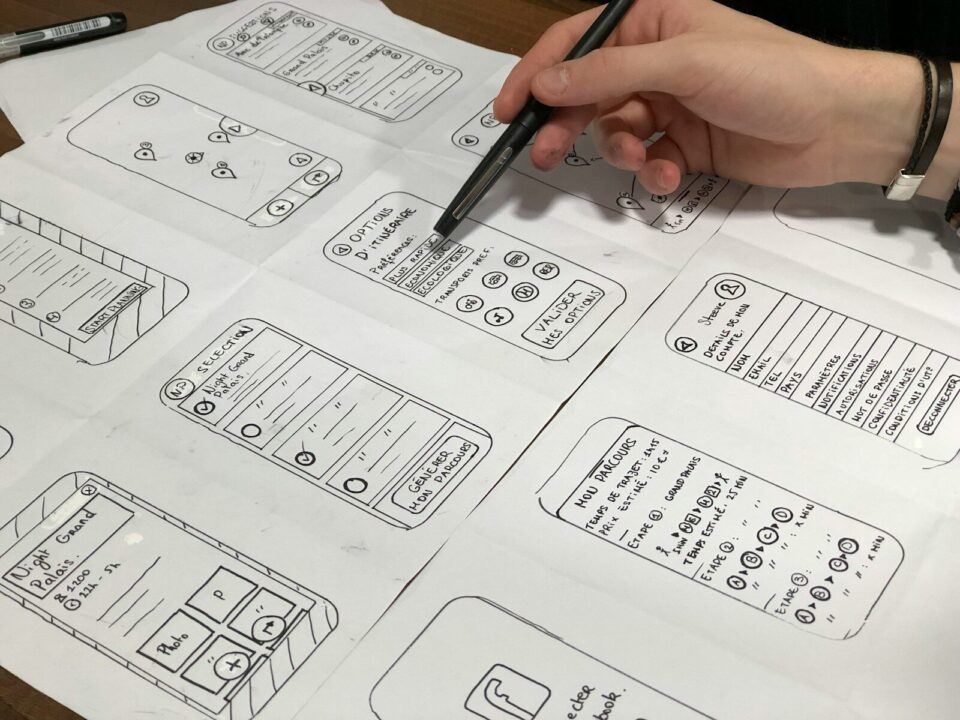 Persona dibujando bocetos de iconos web y pantallas de una interfaz